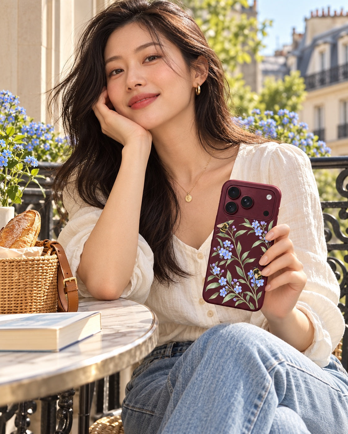 Woman in linen styling the Forget Me Bloom floral case at a sunny cafe