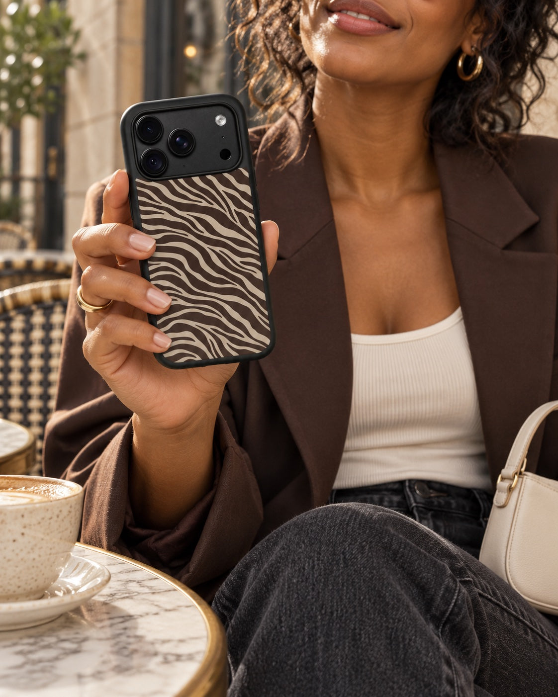 Woman in a chocolate blazer holding the Cocoa Zebra case