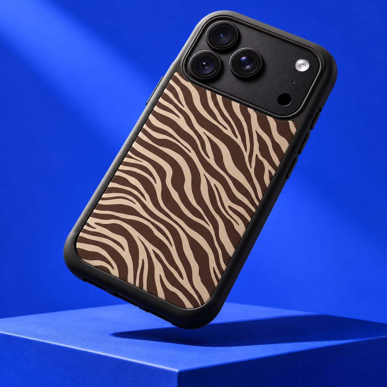 Close-up of Cocoa Zebra case's protective black bumper against a cobalt studio backdrop
